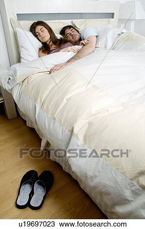 Stock Image - Young couple in bed sleeping. Fotosearch