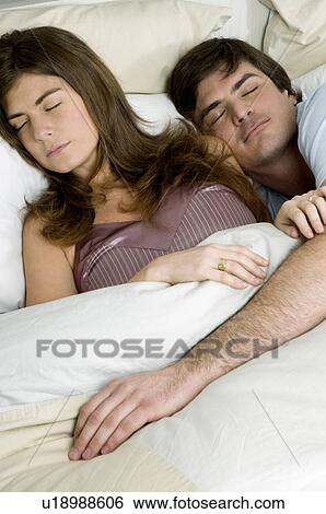 Stock Photograph - Young couple in bed sleeping. Fotosearch