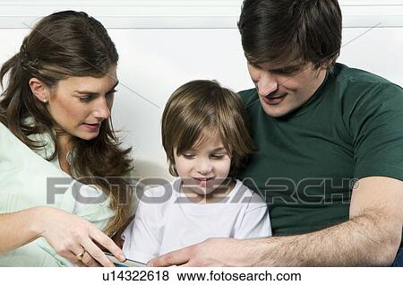 Young couple on couch with boy reading View Large Photo Image Stock Photo - Young couple on couch with boy reading. Fotosearch