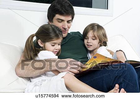 Young man on couch with children reading View Large Photo Image Picture - Young man on couch with children reading. Fotosearch