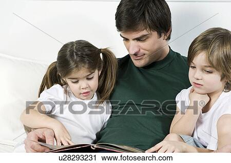 Young man on couch with children reading View Large Photo Image Stock Image - Young man on couch with children reading. Fotosearch