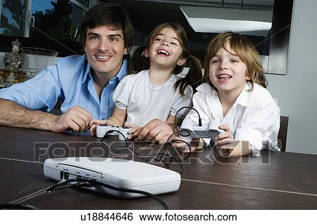 Young man with children playing video game View Large Photo Image Stock Photograph - Young man with children playing video game. Fotosearch