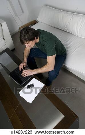 Young man with laptop computer and phone View Large Photo Image Stock Image - Young man with laptop computer and phone. Fotosearch