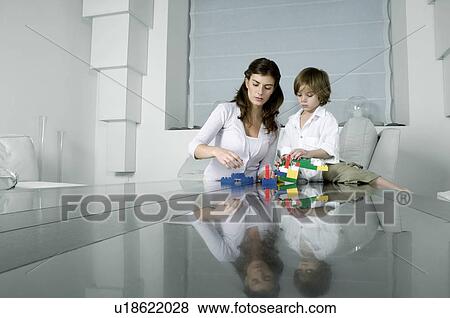 Stock Photo - Young woman and boy playing with building blocks. Fotosearch