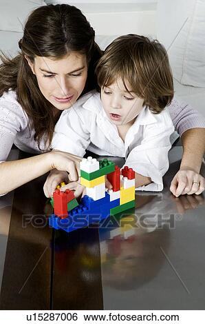 Young woman and boy playing with building blocks View Large Photo Image Stock Photograph - Young woman and boy playing with building blocks. Fotosearch