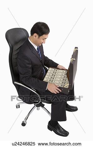 ビジネスマン 椅子 の 着席 そして 保有物 A スーツケース で 紙幣 ビジネス 人々 ストックフォト 写真素材 U Fotosearch