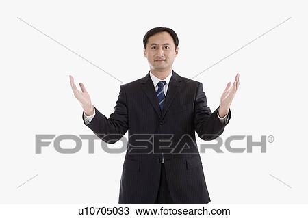 Stock Image - Businessman reaching out hands and looking at the camera, Business People. Fotosearch