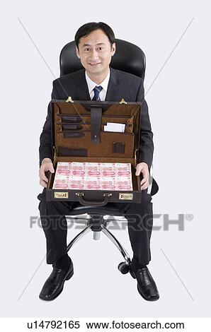 Businessman sitting on chair and holding a suitcase of paper money, Business People View Large Photo Image Stock Photography - Businessman sitting on chair and holding a suitcase of paper money, Business People. Fotosearch