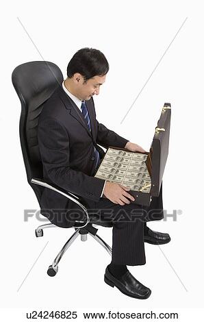 Businessman sitting on chair and holding a suitcase with paper money, Business People View Large Photo Image Stock Photography - Businessman sitting on chair and holding a suitcase with paper money, Business People. Fotosearch