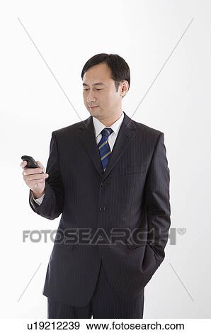 Stock Photo - Businessman using mobile phone and looking down, Business People. Fotosearch