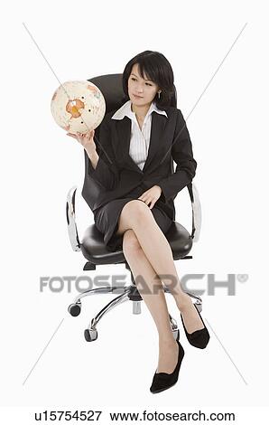 Stock Photo - Businesswoman sitting on chair and holding a globe, Business People. Fotosearch