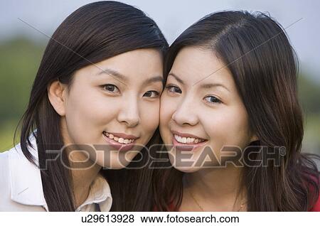 Stock Photo - Close-up of two young women smiling happily. Fotosearch