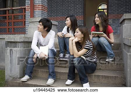 Four young college students sitting on the stairs and looking away, Studying, Education View Large Photo Image Stock Photography - Four young college students sitting on the stairs and looking away, Studying, Education. Fotosearch