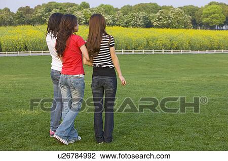Three women standing on the lawn and looking away View Large Photo Image Stock Image - Three women standing on the lawn and looking away. Fotosearch