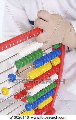 Stock Photograph - Baby boy playing with a toy abacus, Child. Fotosearch