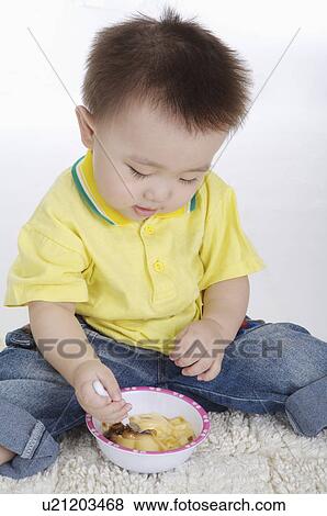 Baby boy sitting and eating, Child View Large Photo Image Stock Photo - Baby boy sitting and eating, Child. Fotosearch