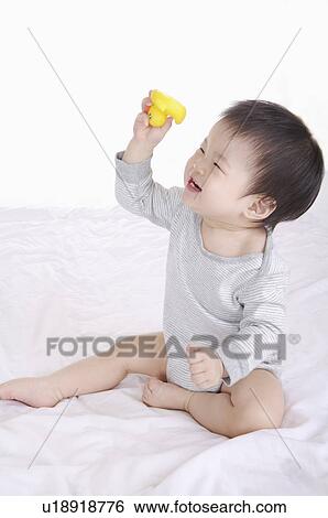 Baby boy sitting and holding a rubber duck with smile, Child View Large Photo Image Stock Photograph - Baby boy sitting and holding a rubber duck with smile, Child. Fotosearch