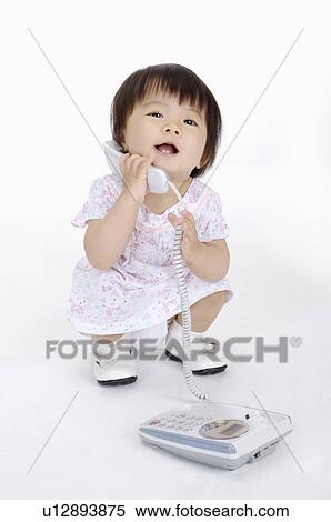 Baby girl crouching and holding telephone, Child View Large Photo Image Stock Photography - Baby girl crouching and holding telephone, Child. Fotosearch