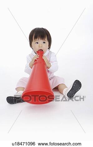 Baby girl sitting and playing with a toy speaker, Child View Large Photo Image Stock Photograph - Baby girl sitting and playing with a toy speaker, Child. Fotosearch