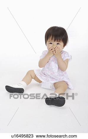 Baby girl sitting and smiling with hands on mouth, Child View Large Photo Image Stock Image - Baby girl sitting and smiling with hands on mouth, Child. Fotosearch