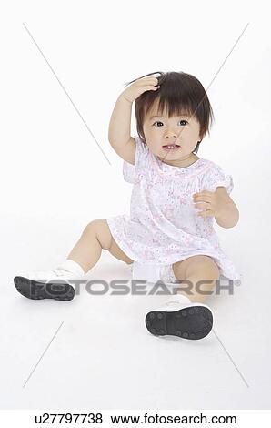 Baby girl sitting with hand in hair and smiling, Child View Large Photo Image Stock Photo - Baby girl sitting with hand in hair and smiling, Child. Fotosearch