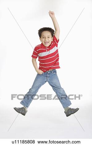 Boy jumping high and smiling happily, Child View Large Photo Image Stock Photo - Boy jumping high and smiling happily, Child. Fotosearch