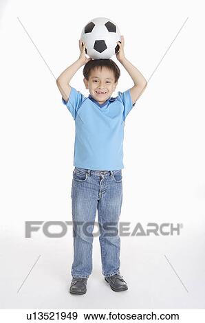 Boy standng and holding a football on head, Child View Large Photo Image Stock Photo - Boy standng and holding a football on head, Child. Fotosearch