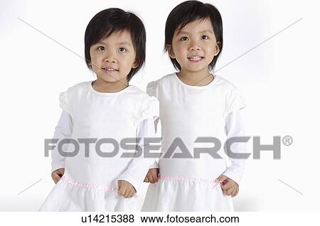 Stock Photo - Two little girls standing together and looking up, Child. Fotosearch