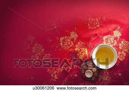 Stock Photograph - A cup of tea and Chinese decoration on a red cloth, CG, Chinese Culture, Backgrounds. Fotosearch