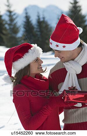 Couple in Christmas outfit, giving a present View Large Photo Image Stock Image - Couple in Christmas outfit, giving a present. Fotosearch