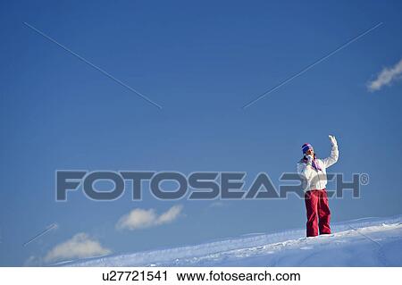 Young woman in snow talking on mobile and waving View Large Photo Image Stock Image - Young woman in snow talking on mobile and waving. Fotosearch