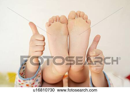 Girl showing soles of her feet and hands with thumbs up View Large Photo Image Stock Image - Girl showing soles of her feet and hands with thumbs up. Fotosearch