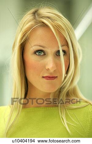 Picture - Portrait of young business woman with long blond hair wearing green sweater. Fotosearch