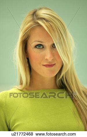 Stock Photo - Portrait of young business woman with long blond hair wearing green sweater. Fotosearch