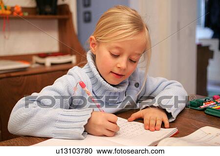 Stock Image - School girl doing homework exercises. Fotosearch