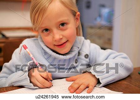 Stock Photography - School girl doing homework exercises. Fotosearch