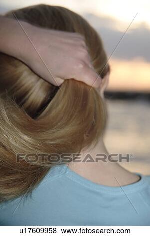 Woman holding hair, standing at the beach at sunset, rear view, close up of hair View Large Photo Image Stock Photo - Woman holding hair, standing at the beach at sunset, rear view, close up of hair. Fotosearch