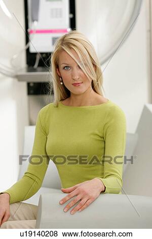 Young business woman sitting in a modern hotel lounge, public phone in background View Large Photo Image Stock Photo - Young business woman sitting in a modern hotel lounge, public phone in background. Fotosearch