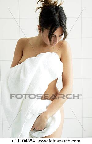 Young woman getting out of bathtub, rubbing herself dry with towel View Large Photo Image Picture - Young woman getting out of bathtub, rubbing herself dry with towel. Fotosearch