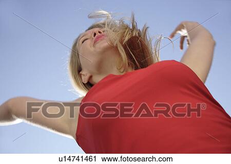 Young woman with arms stretched out in front of blue sky, low angle view View Large Photo Image Stock Image - Young woman with arms stretched out in front of blue sky, low angle view. Fotosearch