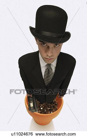 Stock Photograph - A man wearing a suit standing in a flower pot. Fotosearch