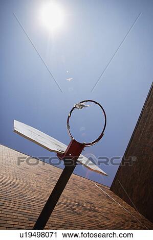 Stock Image - Basketball hoop against blue sky. Fotosearch
