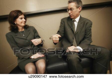 Stock Photo - Business couple in handcuffs. Fotosearch
