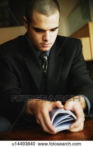 Stock Image - Businessman shuffling cards. Fotosearch