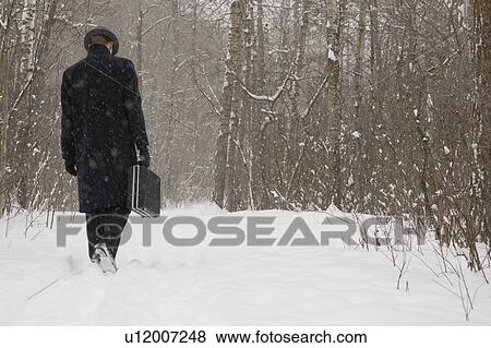 Stock Photo - Businessman walking through the snow. Fotosearch
