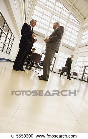Stock Image - Businessmen discussing. Fotosearch