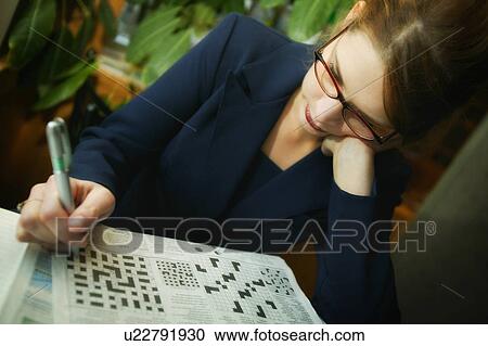 Businesswoman working on crossword puzzle View Large Photo Image Stock Image - Businesswoman working on crossword puzzle. Fotosearch