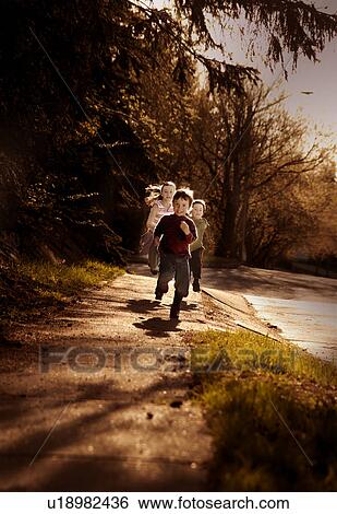 Stock Photograph - Children chasing each other. Fotosearch