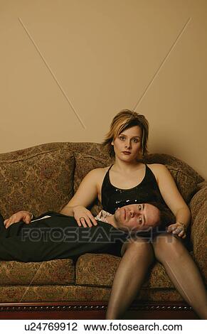 Stock Image - Couple hang out on the sofa. Fotosearch