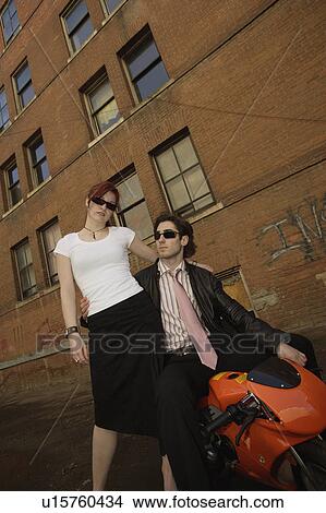 Picture - Fashionable couple and mini motorcycle. Fotosearch